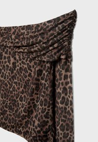 Tkanina s uzorkom leoparda u nijansama smeđe i crne boje. Ima nabranu teksturu na vrhu i lepršav dizajn.