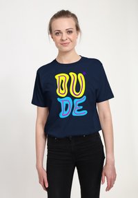 Camiseta azul marino de algodón, con el texto colorido "DUDE" en amarillo, rosa y azul. Manga corta, escote redondo, corte relajado.