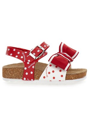 Sandales rouges à pois blancs avec une semelle en liège, une semelle blanche, une boucle ajustable et un nœud décoratif sur la bride.