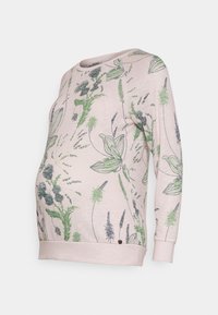 Sweat-shirt de maternité en tissu rose clair avec motifs floraux verts et noirs. Il présente un col rond et des manches longues avec des bords côtelés.
