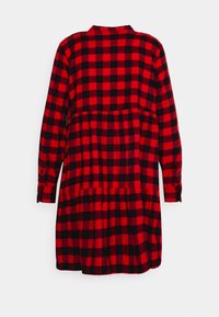 Vestito camicia a quadri rossi e neri con maniche lunghe, polsini con bottoni, vita arricciata e gonna a balze.