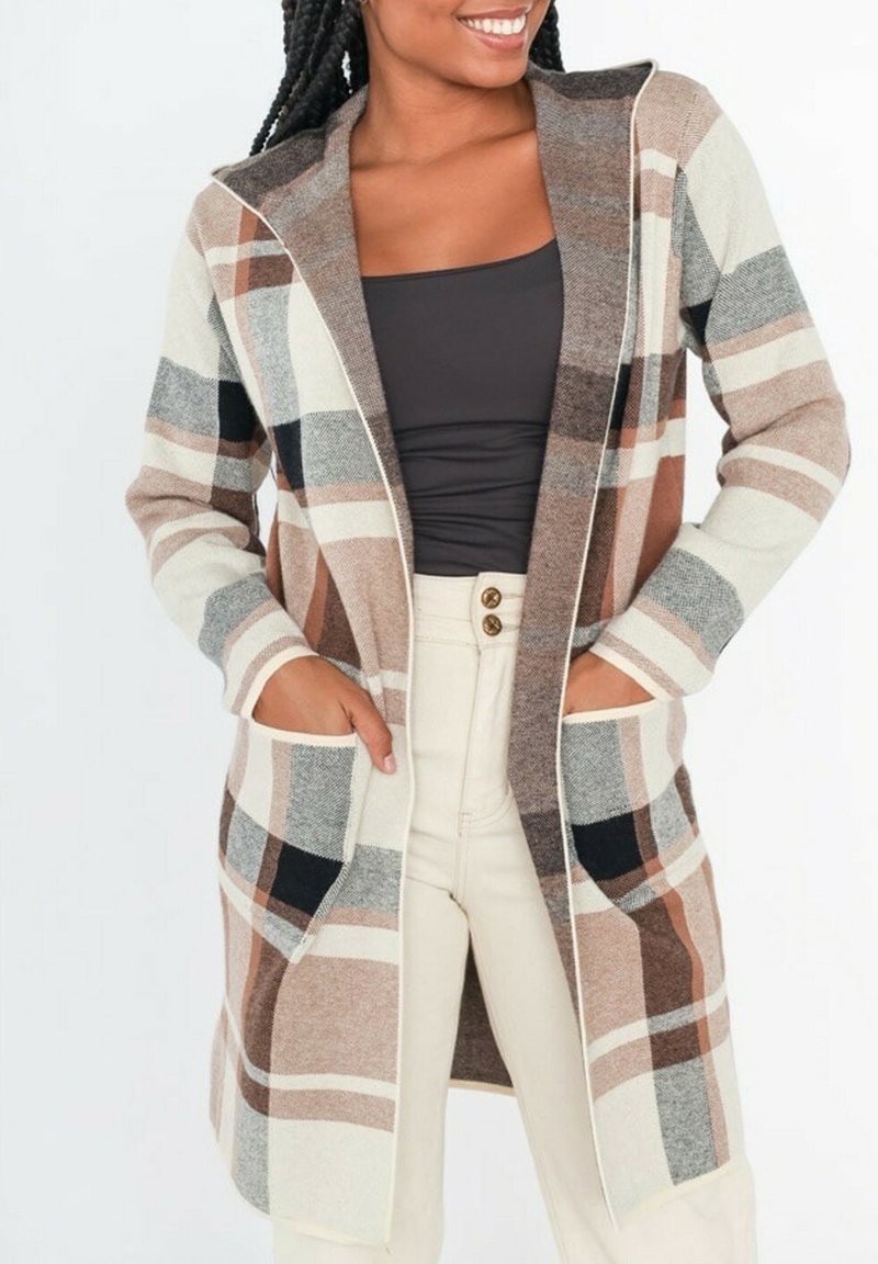 Cardigan à carreaux beige et marron avec des manches longues, devant ouvert et deux poches avant. Le tissu semble doux avec des lignes de couleur contrastante.