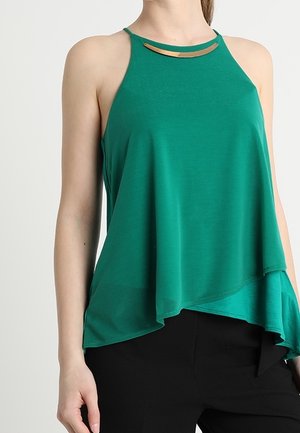 Zielony, bezrękawnik z wysokim dekoltem i wycięciem oraz drapowanym dołem. Wykonany z gładkiego materiału o luźnym kroju.