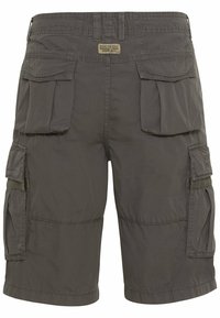 Bermuda cargo gris foncé avec plusieurs poches à rabat et un petit patch indiquant "Conçu pour les aventures quotidiennes depuis 1977" sur la ceinture.