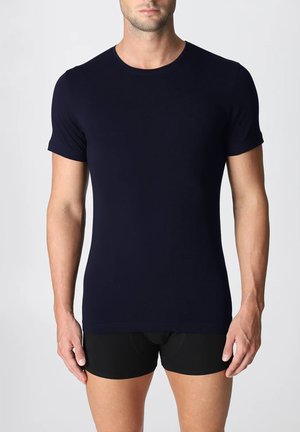 T-shirt blu navy a maniche corte realizzato in un tessuto morbido ed elastico. Caratterizzato da un collo rotondo e un design slim fit, abbinato a pantaloni corti neri.