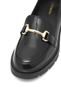 Lofer din piele patent neagră cu un accent din metal auriu, talpă chunky neagră și design cu vârf rotund. Textură netedă cu finisaj lucios.