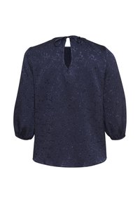 Blusa blu navy realizzata in tessuto testurizzato con apertura a chiave sul retro e chiusura a cravatta. Presenta maniche a palloncino e un design morbido.
