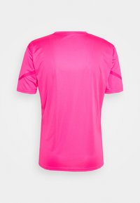 Sportovní tričko s krátkým rukávem v jasně růžové barvě, vyrobené z hladké, lehké látky. Má kulatý výstřih a jemné švy na rukávech.