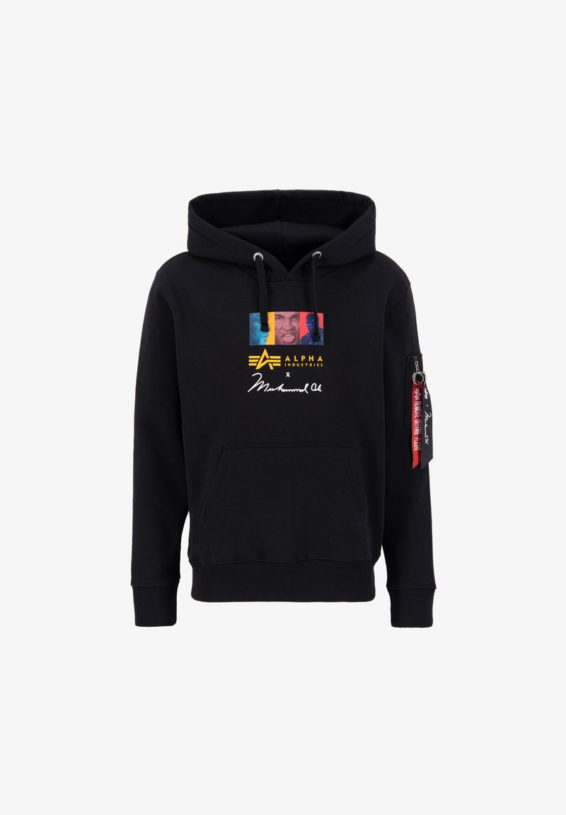 Sweat à capuche noir avec un graphisme coloré et le texte « Alpha Industries x Muhammad Ali » sur le devant, poche zippée et étiquette rouge sur la manche gauche.
