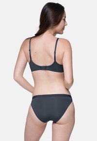 Melnas krūšturis un bikini komplekts ar regulējamiem siksniņām un āķa aizdari. Gluda tekstūra un vienkāršs dizains ar viļņotām apmalēm.