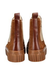 Braune Wildleder- und Lederstiefeletten mit einer tanfarbenen Gummisohle. Mit einem Griff an der Hinterseite für einfaches An- und Ausziehen sowie einem dezenten Logo an der Seite.