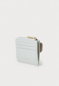 Portefeuille en cuir gris clair avec une finition texturée, doté d'une fermeture éclair et de plusieurs emplacements pour cartes. Accents en matériel doré sur la fermeture éclair.