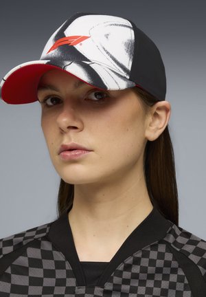 Czarna i biała czapka w kratę z czerwonymi akcentami, z wyraźnym logo na przodzie. Materiał wydaje się lekki i ma usztywnioną konstrukcję.