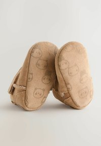 Pantofole per bambini in suede beige con motivi a forma di animale, texture morbida e dettagli cuciti. Forma arrotondata con suola flessibile per il massimo comfort.