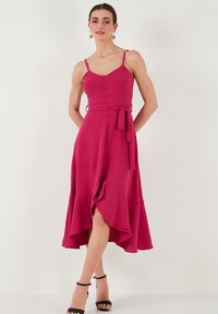Fuktsia midi-mekko ohutolkaimilla, etupainikkeilla, vyötäröllä kietomisnauhalla ja röyhelöhelmalla. Valmistettu tekstuuri- ja kevyestä kankaasta.