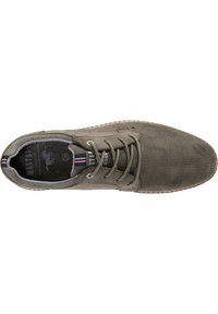 Sneaker in rete verde con punta arrotondata, design con lacci e superficie testurizzata. Presenta una soletta scura a contrasto e accenti a righe.