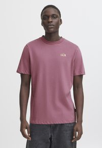Rosenfarvet bomulds-t-shirt med korte ærmer og rund hals. Har en lille guld "KEEP CALM" tekst på brystet.