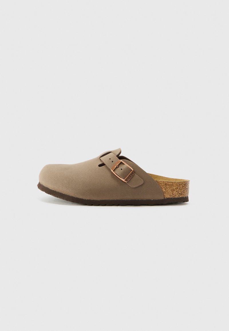 Sabot en daim brun avec un semelle en liège, une sangle ajustable en métal doré rose, bout arrondi, semelle en caoutchouc et texture lisse.