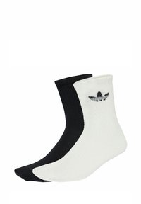 Black and white ankle socks with ribbed texture; features a logo on the white side. The black sock has a smooth finish.
