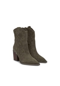 Botines de ante en verde oliva con punteras afiladas, costuras de estilo western y un tacón de madera grueso. Cierre de cremallera en la parte trasera.