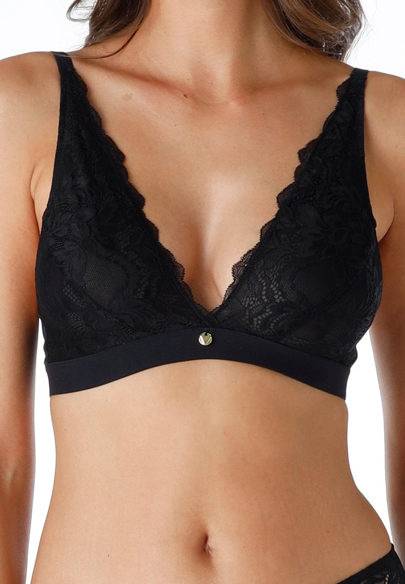 Bralette in pizzo nero con scollatura a V profonda, motivo floreale e banda liscia. Presenta un accento metallico al centro davanti. Texture morbida.