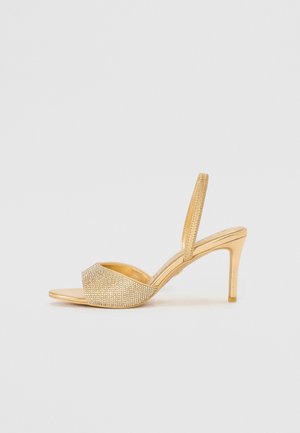 Zlaté sandále na opätku so slingbackom s hladkým materiálom, zdobené trblietavými kamienkami na prednom remienku, s úzkym dizajnom vysokého opätka.