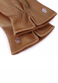 Braune Lederhandschuhe mit einer weichen Textur, die ein einzigartiges Design mit einem Totenkopf-Emblem und genähten Details im Handgelenkbereich aufweisen.