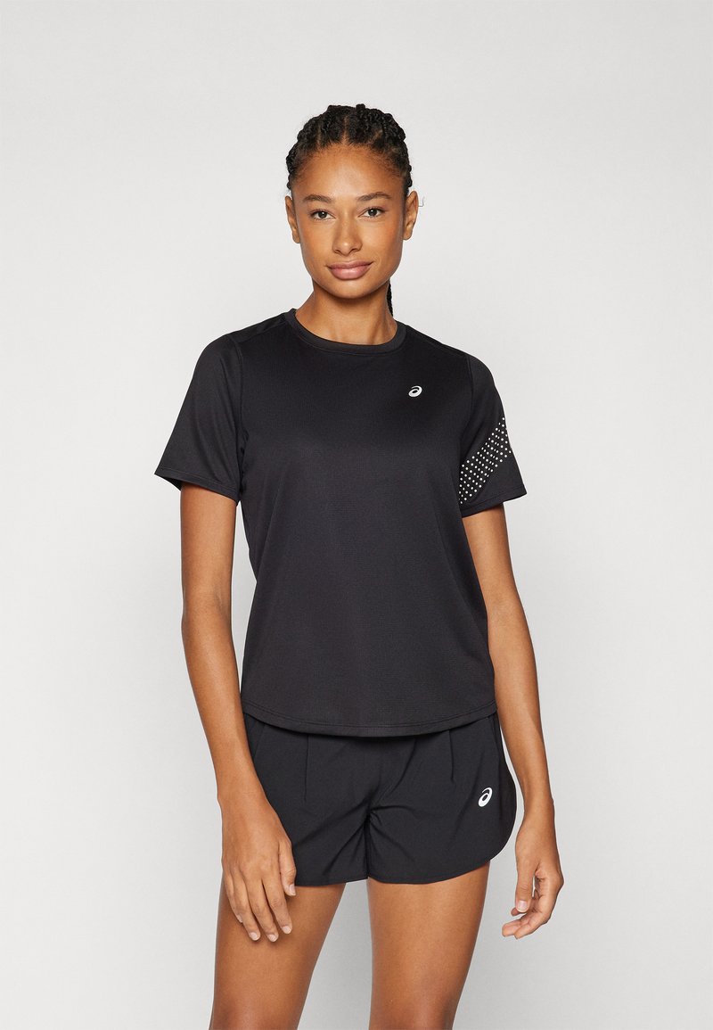 Sort sports t-shirt med korte ærmer, der har en struktureret søm og et prikket mønster på den ene ærme. Sættes sammen med sorte shorts.