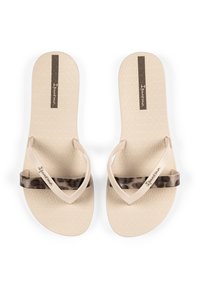 Beige flip-flops with textured soles, featuring a light tan strap and a dark leopard print accent strap. Brand logo visible on the insole.