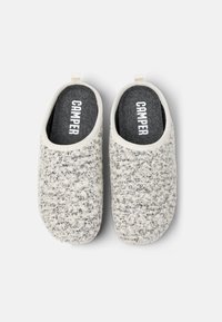 Grå- och vita filtskor med en mjuk strukturerad yta, rundad form och en kontrasterande mörk innersula med "CAMPER"-logotyp.
