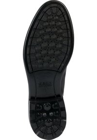 Suela de zapato de goma negra con un patrón texturizado que presenta agarres circulares y agujeros de ventilación. Marcada con "GEOX ULTRA COMFORT."