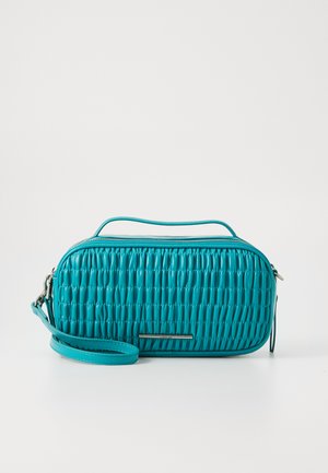 Teal quilted handbag with a top handle and removable shoulder strap. Features a smooth finish and silver-tone branding detail at the front.