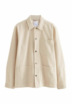 Veste en denim beige avec un devant à boutons, un col, une poche poitrine et deux poches inférieures. Présente une texture subtile et des boutons en métal.