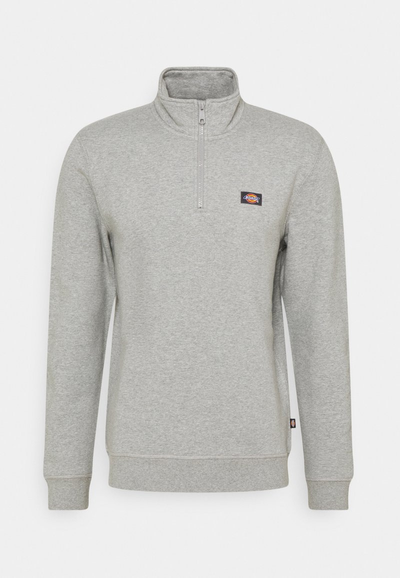 Sweatshirt cinza claro com gola metade de zíper, punhos em malha e barra. Apresenta um pequeno logotipo colorido da marca no peito esquerdo. Textura suave.