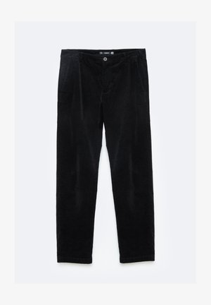 Mustard värvi plyšist kangast sirged püksid, millel on ees taskud ja nööp sulgemine keha ümber. Pehme tekstuur, tagasihoidlik sooniline muster.