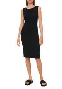 Robe midi noire à côtes avec un design sans manches et un col bateau, associée à des sandales à glissière texturées noires.