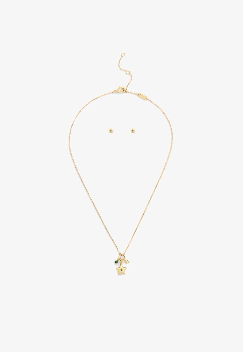 Guldtonet halskæde med en stjernevedhæng og grøn accent, parret med matchende stjerne øreringe med sten. Kæde med justerbar lukning.