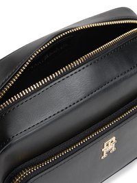 Black leather crossbody bag with gold zippers. Features a front zip pocket and a logo accent. Smooth texture with clean lines.