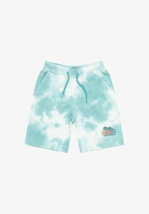 T-shirt blanc avec le logo "Quiksilver" coloré, shorts teal tie-dye, et chaussures noires. Présente des graphismes de palmiers multicolores.