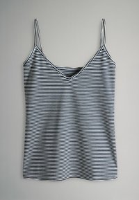 Gestreifter Trägershirt mit dünnen Spaghettiträgern, V-Ausschnitt, aus weichem Stoff in schwarz-weißen Horizontalstreifen.