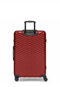 Maleta dura roja con surcos diagonales, asa telescópica negra, asa lateral y cuatro ruedas giratorias.