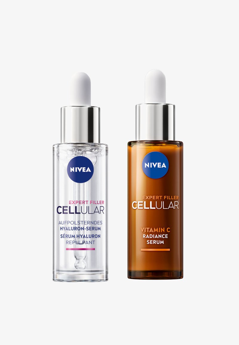 Die klare Glas-Dropperflasche links enthält ein farbloses Serum; die bernsteinfarbene Glasflasche rechts enthält ein goldenes Serum. Beide sind mit "NIVEA" beschriftet.