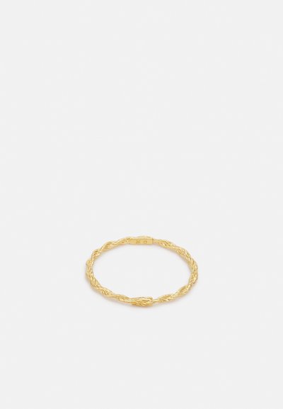 Verdrehter goldener Ring mit texturiertem Oberfläche, der ein offenes Design aufweist. Minimalistische Ästhetik mit polierter Oberfläche und subtiler Markenkennzeichnung.