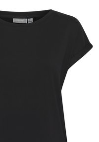 T-shirt noir à manches courtes avec col rond, manches retroussées et étiquette de marque visible à l'intérieur du col.