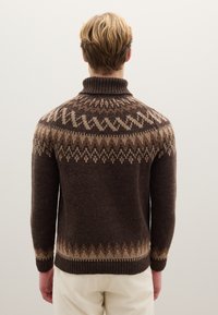 Brown knitted sweater with a high collar, featuring a geometric pattern in light brown shades along the shoulders and hem.