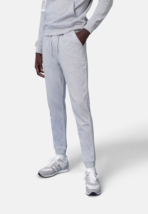 Felpa grigia e set di pantaloni jogger abbinati realizzati in tessuto morbido. I jogger presentano una vita elasticizzata, tasche laterali e gambe affusolate.