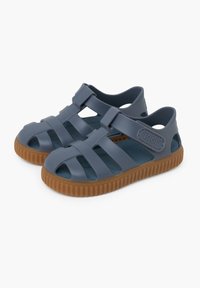 Blue rubber sandals with a strap design, open toe and sides, and a brown textured sole. Features the brand name "igor" on the side.