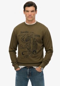 Felpa verde oliva realizzata in cotone con polsini e collo a coste. Presenta una stampa grafica nera di una tigre e del testo sul davanti.