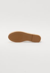 Suola di scarpa in gomma marrone con finitura testurizzata e scanalature orizzontali, caratterizzata da una forma arrotondata e un design con tacco piatto.