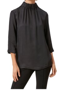 Czarna bluzka z wysokim marszczonym dekoltem i rękawami o długości trzy czwarte. Tkanina ma gładką fakturę i luźny, zwiewny krój.